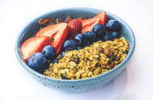 a blue bowl filled with oatmeal and fresh fruit