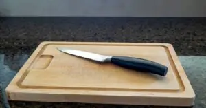 paring knife on a large wooden cutting board