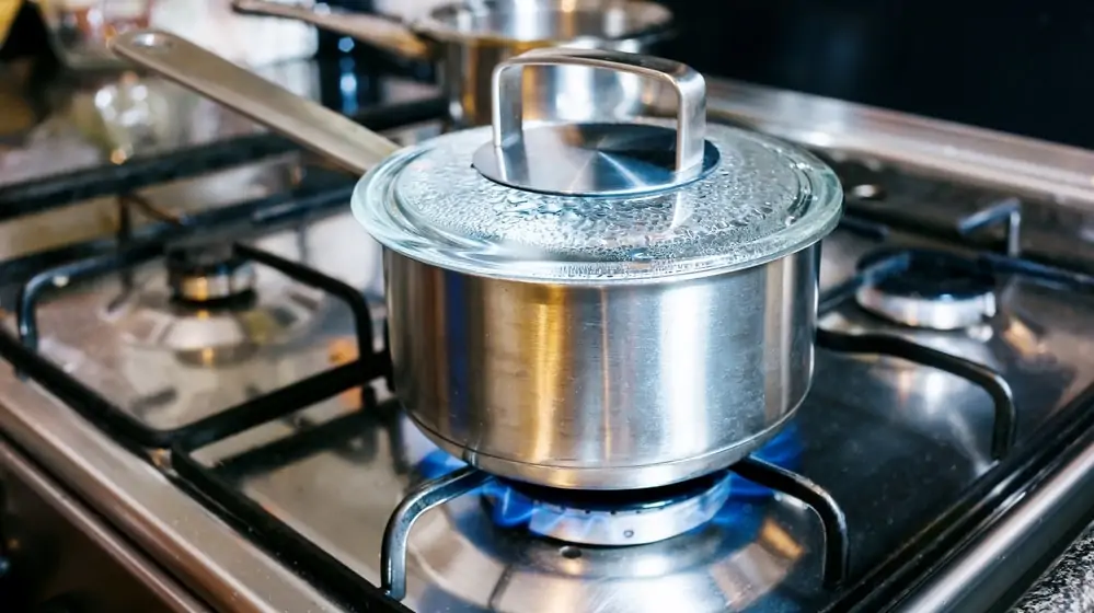 stainless steel saucepan at the kitchen fire with boiling water